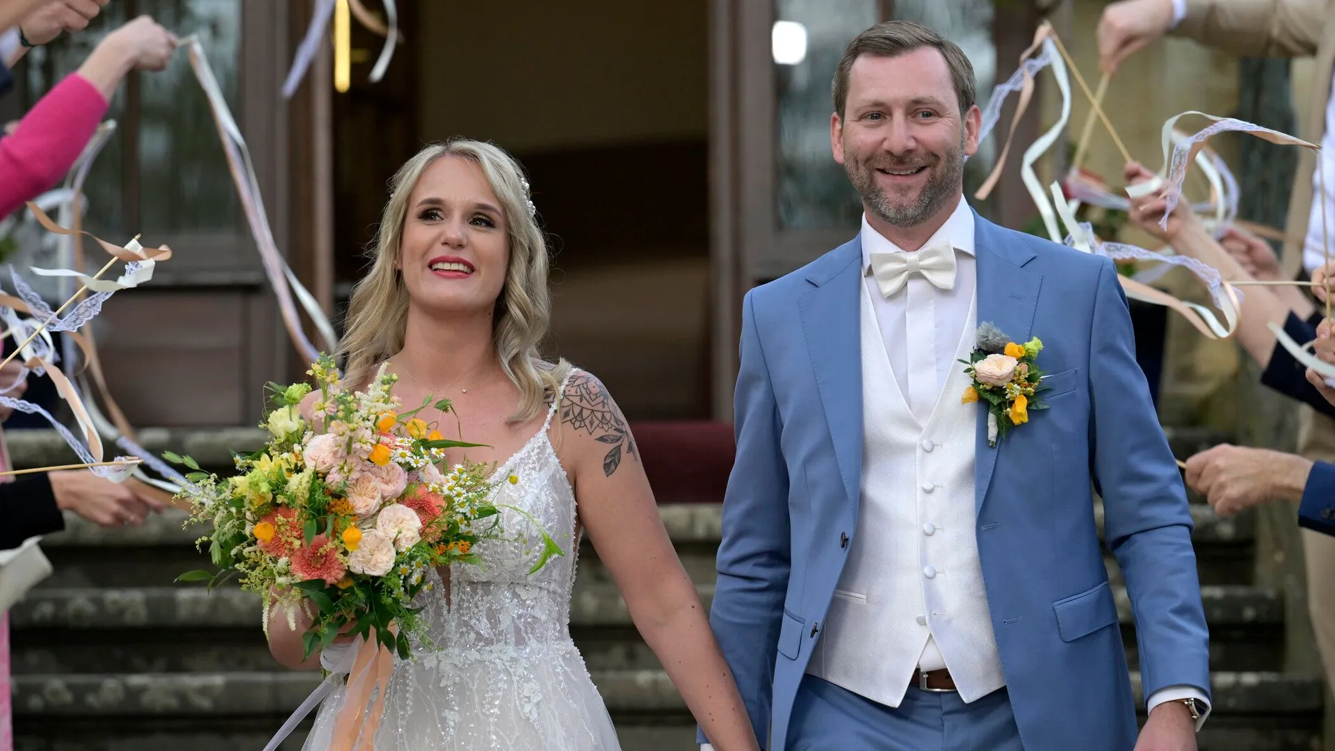 Michelle und Fabian verlassen als frisch verheiratetes Paar die Hochzeitslocation